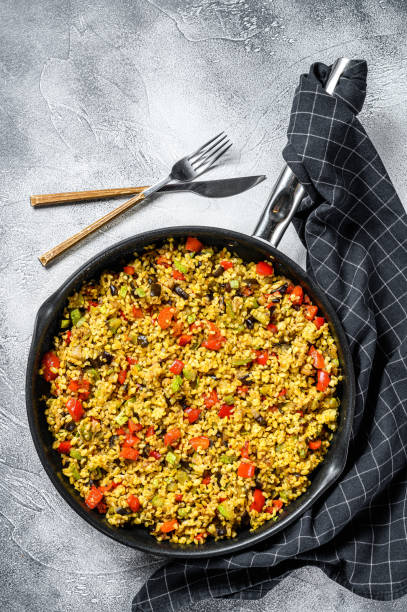 istock Cooked bulgur with vegetables and chicken meat in a pan. Gray background. Top view 1249643851