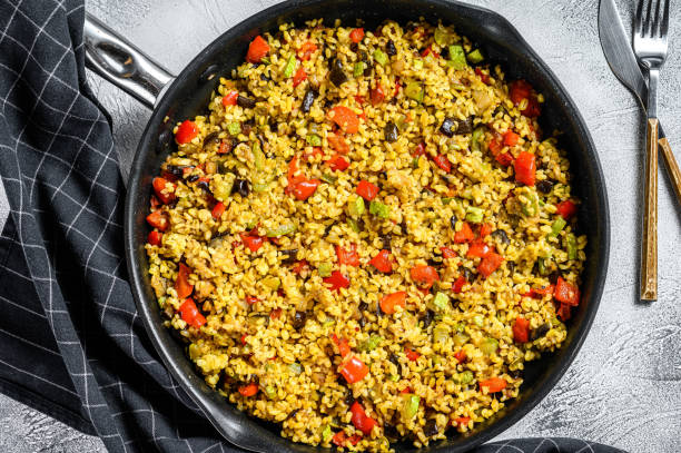 istock Cooked bulgur with vegetables and chicken meat in a pan. Gray background. Top view 1249646574