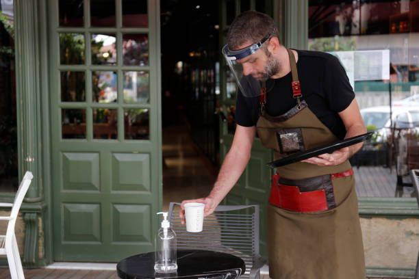 Man working in cafe, with face mask