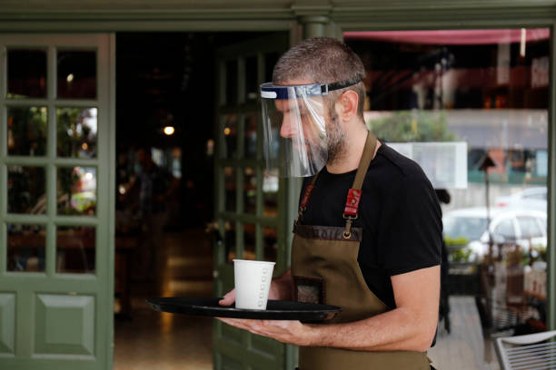Man working in cafe, with face mask
