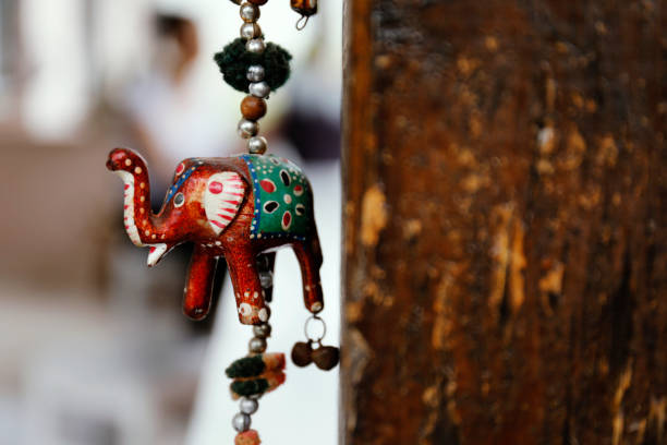Wind chimes with bells and decorated elephant model.