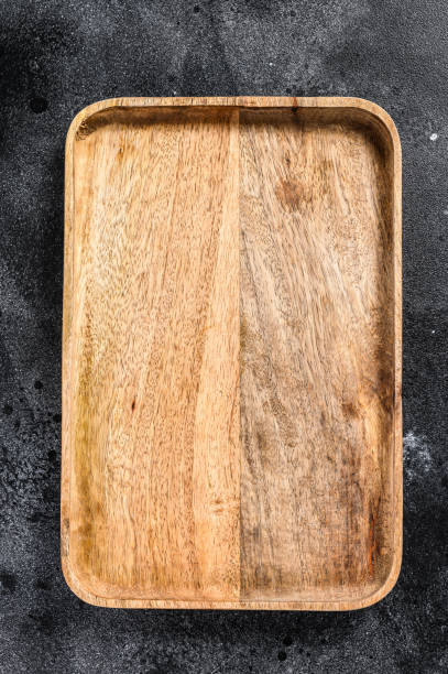 istock Wooden antique tray. Black texturized background. Top view. Copy space 1249659228