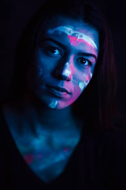 istock Portrait painted with fluorescent make-up in ultraviolet light 1249660752