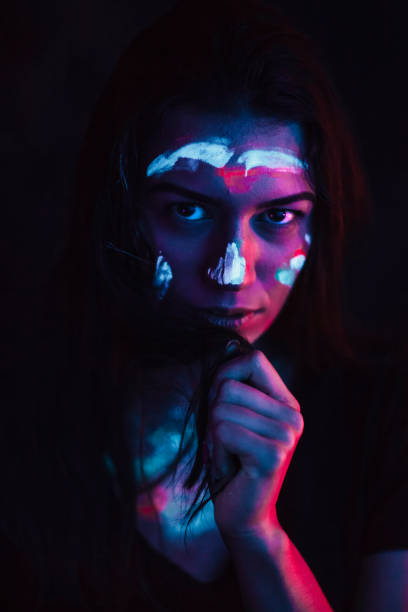 istock Portrait painted with fluorescent make-up in ultraviolet light 1249660760