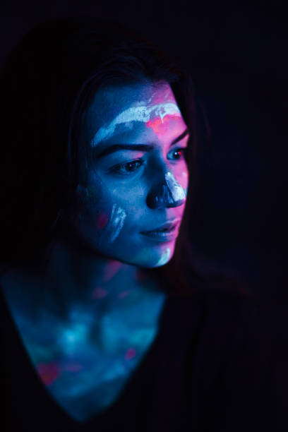 istock Portrait painted with fluorescent make-up in ultraviolet light 1249660763