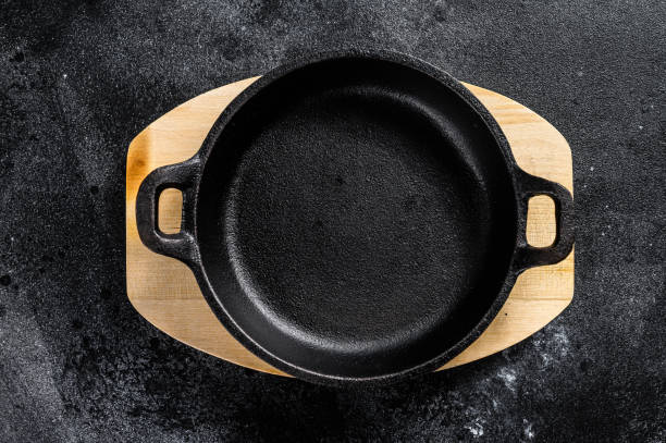 istock Empty cast iron frying pan on dark background. Top view. Copy space 1249660782