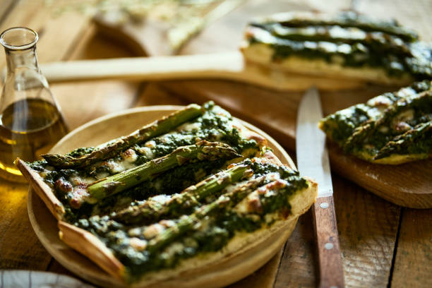 homemade pizza with asparagus and spinach on a rustic wooden table - fochaccia imagens e fotografias de stock