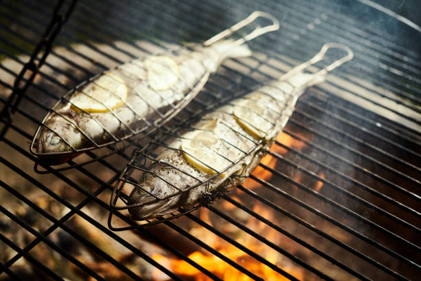 delicious trout with spices roast on a grill over a fire in the summer forest