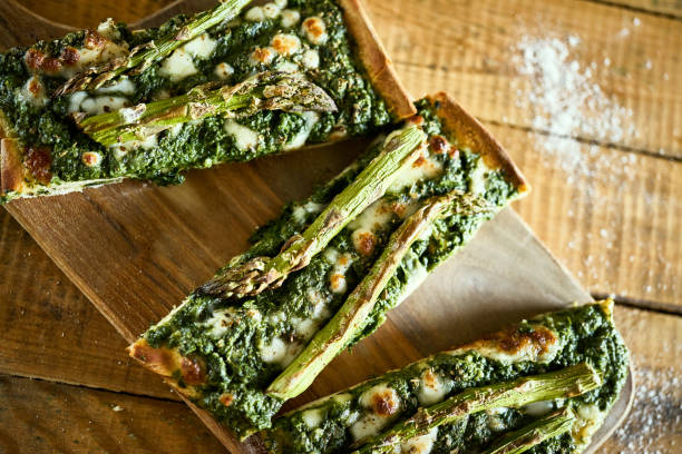 homemade pizza with asparagus and spinach on a rustic wooden table - fochaccia imagens e fotografias de stock