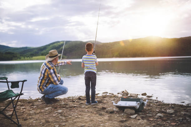 father and son fishing at sunset. - fishing supplies imagens e fotografias de stock