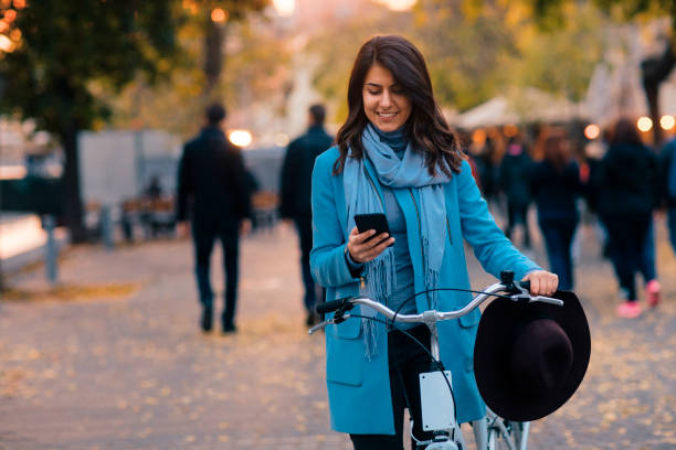 istock A Woman Riding a Bike and Using Cell Phone 1249667819