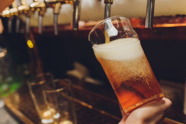 istock Barkeeper pulling a pint of beer behind the bar. 1249670855