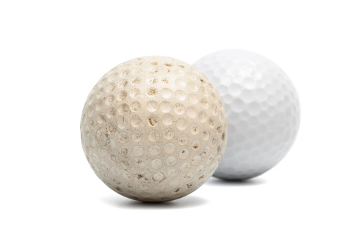 old and new golf ball on a white background