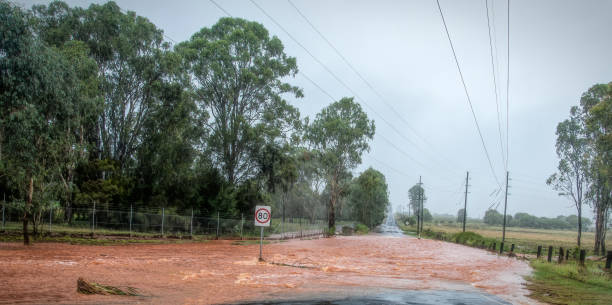 Highway Flooding Flood waters across the road in rural Queensland queensland floods stock pictures, royalty-free photos & images