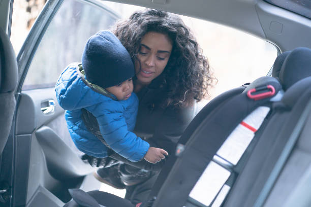 istock Mother places child into car seat 1249681494