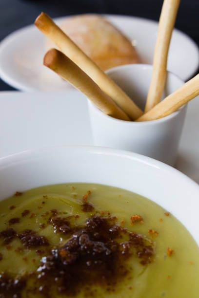 istock Green pea cream soup in bowl with sprouts, bread toasts 1249681571