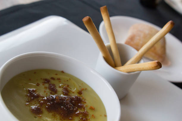 istock Green pea cream soup in bowl with sprouts, bread toasts 1249681665