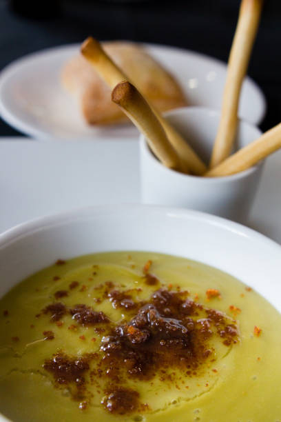 istock Green pea cream soup in bowl with sprouts, bread toasts 1249683308
