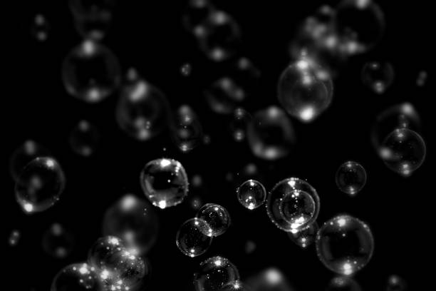 istock Transparent soap bubbles floating on the dark or black background. 1249692926