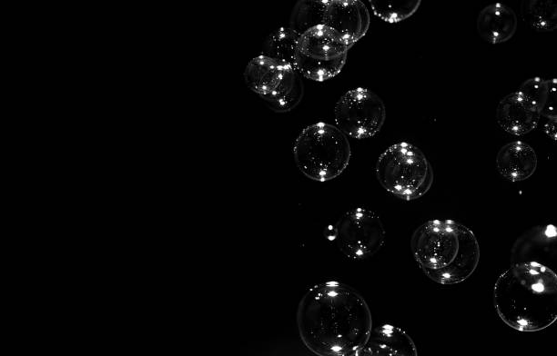 istock Transparent soap bubbles floating on the dark or black background. 1249692927