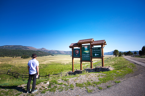 Jemez Springs, NM: A man looks at a sign at the entrance to Valles Caldera National Preserve.