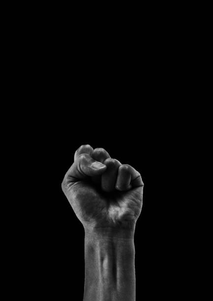 clenched fist isolated on black background - human hand reaching human arm gripping imagens e fotografias de stock