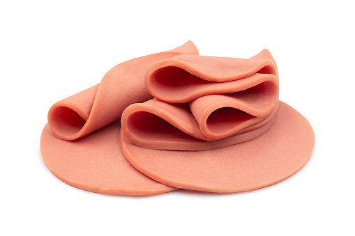 Sliced of bologna sausage rolled and heap on white isolated background with clipping path. Bologna sausage origin from Italian,  have delicious taste for sandwich or ABF. Delicatessen concept.