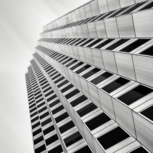 istock Looking up at tall city building in black and white 1249704118