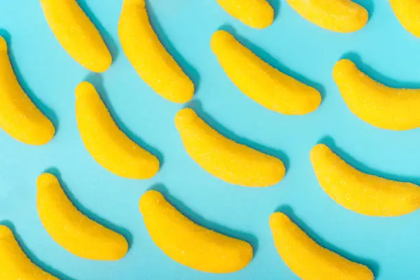 Photo of A pattern of jelly-like yellow chocolates, on blue background