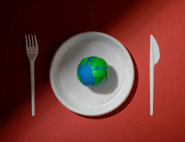 istock Serving table with Earth planet, plastic plate, fork and knife. Ecology Concept for Earth Hour, Earth Day, Ocean Day and other ECO dates. 1249711869