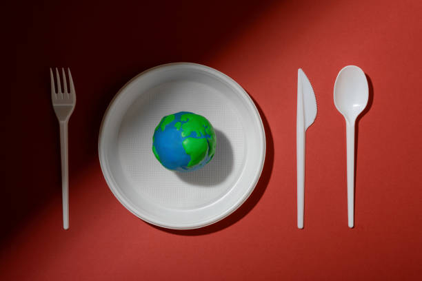 istock Serving table with Earth planet, plastic plate, spoon, fork and knife. Ecology Concept for Earth Hour, Earth Day, Ocean Day and other ECO dates. 1249711995