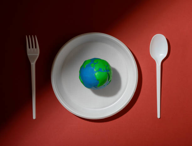 istock Serving table with Earth planet, plastic plate, spoon and fork. Ecology Concept for Earth Hour, Earth Day, Ocean Day and other ECO dates. 1249712295