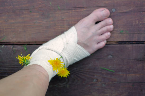 Closeup of an injured leg in bandage decorated with dandelion