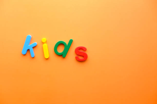 istock colorful plastic letters on orange background, Top view 1249720269