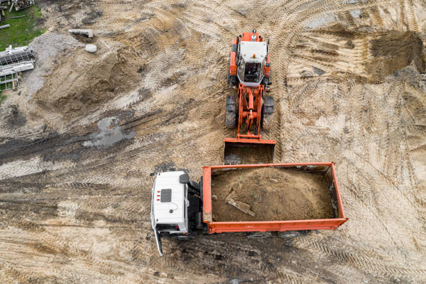 istock an excavator loads sand into a truck on a construction site. Top view from a drone. 1249723053
