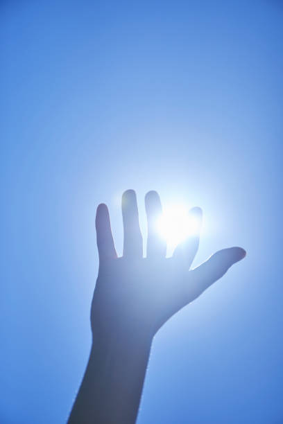 istock Young woman reaching for the blue sky 1249727651