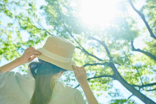 バーデュアに帽子をかぶった若い女性の手 - 麦わら帽子 ストックフォトと画像