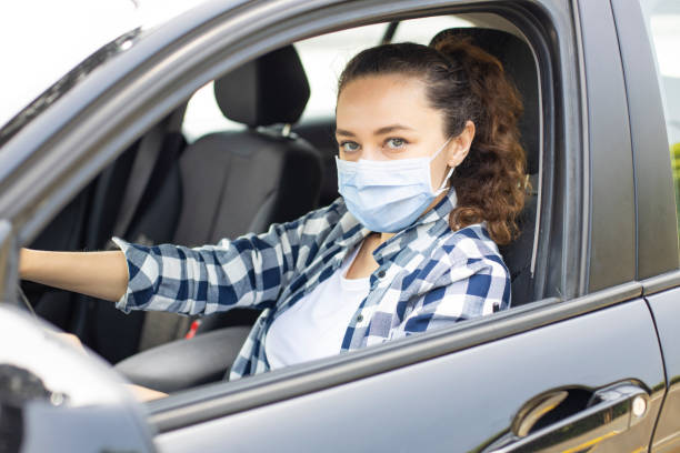 istock Young woman in a mask sitting in a car 1249729229