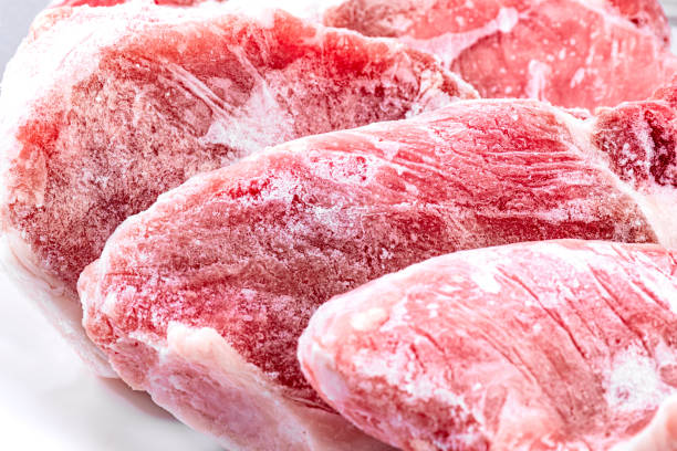 carne cruda congelata. braciole di maiale crude - cibi surgelati foto e immagini stock