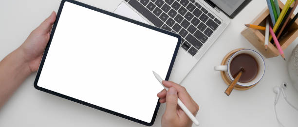 istock Female entrepreneur using blank screen tablet while working with laptop on white office desk 1249734927