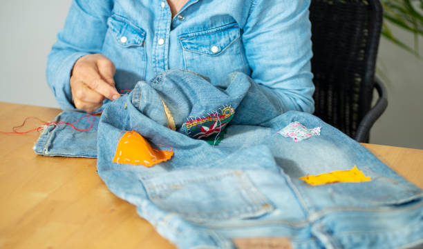 istock an elderly woman hands sewing on fabric jeans, 1249735401