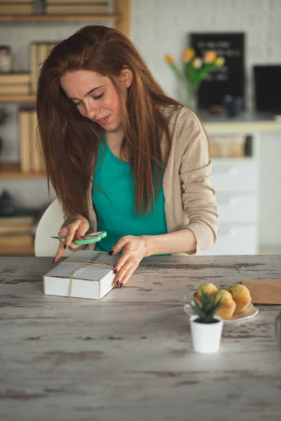 istock Young woman opening a package she got 1249735573