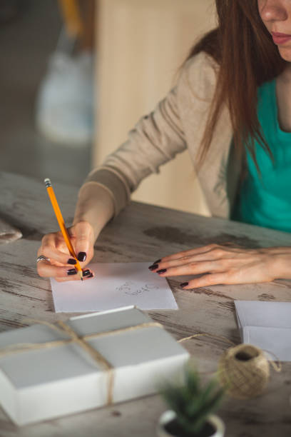 istock Young woman writing a letter to send with a care package 1249735581