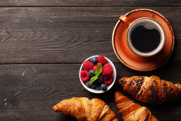 istock Coffee and croissants on wooden table 1249735762