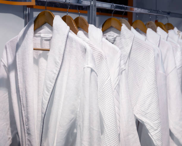 istock White bathrobes hang on wooden hangers. 1249737281
