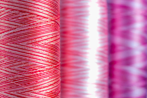 istock Colored melange threads of red hue on bobbins as a close-up background 1249743322