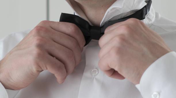 istock The man wears In white shirt a black butterfly 1249744012