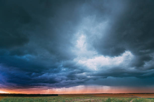 Summer Rainy Sunset Evening Above Rural Field Landscape. Scenic Dramatic Sky With Rain Clouds. Agricultural And Weather Forecast Concept