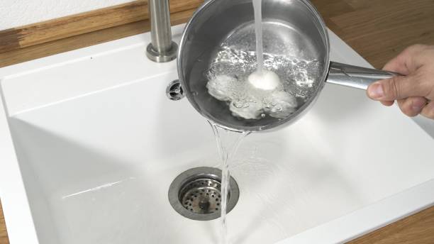 istock Cooling a pot and egg full of hard boiled eggs under running tap water. 1249745089