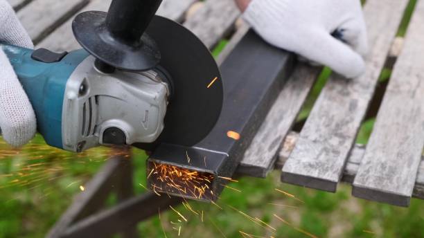istock Hand with circular grinding machine sparks cutting metal profile. 1249745324
